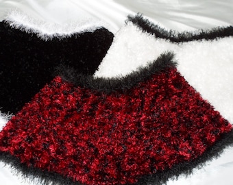 May include: Three fuzzy neck warmers in black, red, and white. Each warmer has a black trim around the edge.