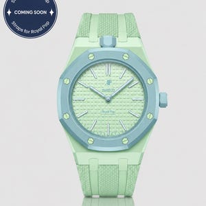 Könnte beinhalten: Eine mintgrüne und hellblaue Armbanduhr mit strukturiertem Armband und Zifferblatt. Die Uhr hat eine hellblaue Lünette und ein hellgrünes Zifferblatt mit dem Text "AP swatch Royal Pop". Ein kreisförmiges Grafik zeigt "Straps for Royal Pop" und "COMING SOON".