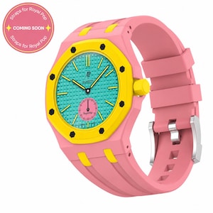 Könnte beinhalten: Eine rosa-gelbe Uhr mit türkisfarbenem Zifferblatt. Die Uhr hat ein rosa Armband und eine gelbe Lünette. Das Zifferblatt trägt den Schriftzug "AP x Swatch" und ein kleines rosa Zifferblatt. Royal Pop Design.