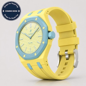Könnte beinhalten: Eine gelbe Armbanduhr mit hellblauer Lünette und Akzenten. Das Zifferblatt der Uhr ist gelb mit silbernen Zeigern und Markierungen. Das Armband ist gelb und hat eine silberne Schnalle. Der Text "Straps for Royal Pop" und "Coming Soon" ist sichtbar.