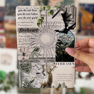Può includere: Una stampa rettangolare con un collage di spartiti, un'illustrazione centrale del sole, la sagoma di un pipistrello, un cervo ed elementi floreali. Il testo include "you do not fear", "fireheart", "TERRASEN" e "ONCE UPON A TIME".