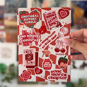 Könnte beinhalten: Ein rechteckiger Bogen mit rot-weißem Karomuster, der mit verschiedenen Aufklebern zum Thema Bücher versehen ist. Die Motive umfassen ein Herz mit Text, ein Buch mit der Aufschrift extra spicy, Würfel, Kirschen, eine Sprühflasche, eine Erdbeere und Text.