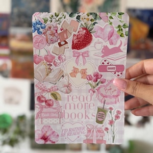 Könnte beinhalten: Ein rechteckiger Aufkleberbogen mit einer Collage aus rosa Illustrationen, darunter Erdbeeren, Kirschen, Kaninchen, Bücher, Schleifen und Blumen. Der Text lautet read more books und I'D RATHER BE READING auf einem hellrosa Vichy-Hintergrund.