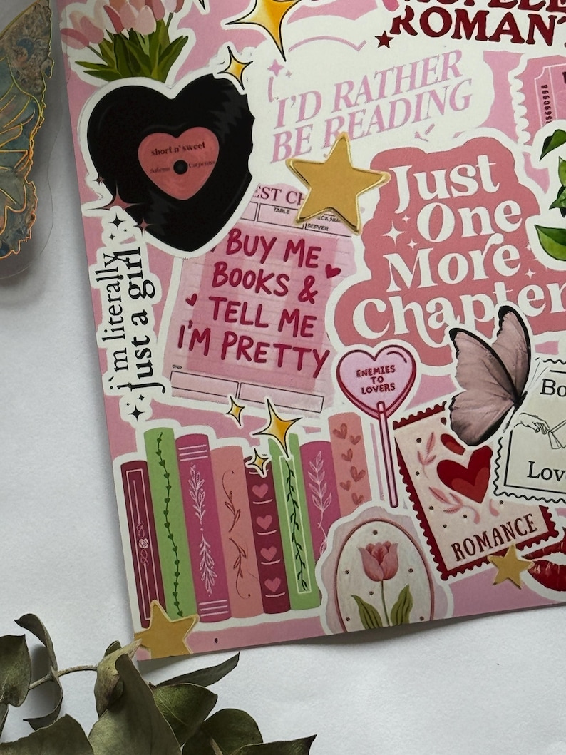 Op de afbeelding: Een verzameling stickers in roze en rode tinten met illustraties van boeken, een vinylplaat, vlinders, tulpen en sterren. De tekst bevat "I'd rather be reading", "Just one more chapter", "Buy me books & tell me I'm pretty" en "Enemies to lovers".