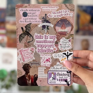 Peut inclure: Une planche d'autocollants rectangulaire sur fond papier vintage avec divers motifs fantastiques. Les designs incluent un dragon, un château, une épée et des textes comme "this is my emotional support Kindle", "Fantasy Book Club" et "To the stars who listen."