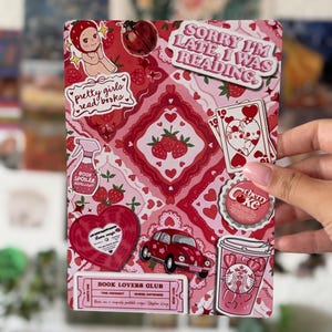 Op de afbeelding: Een rechthoekige print met een collage van rode en roze stickers op een patroonachtergrond. De stickers bevatten een lieveheersbeestje, een rode auto, een koffiebeker, een speelkaart, een hartvormige plaat en de tekst Sorry I'm late, I was reading.