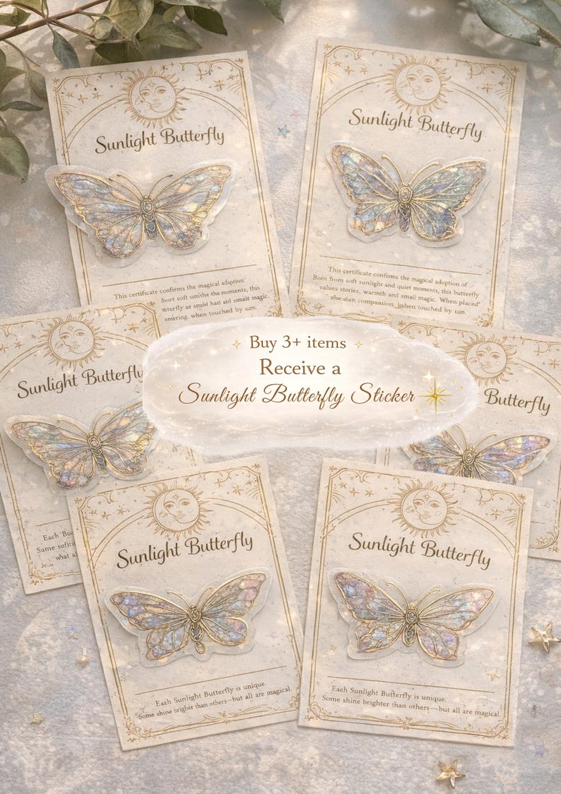 Op de afbeelding: Vijf Sunlight Butterfly stickers op individuele rechthoekige kaarten met gouden illustraties van zon en maan. Elke sticker heeft iriserende, doorschijnende vleugels met gouden omlijningen. Een centrale tekst luidt: Buy 3+ items Receive a Sunlight Butterfly Sticker.