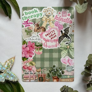 Peut inclure: Une feuille d'autocollants rectangulaire avec un fond à carreaux vert sauge présentant diverses illustrations dont un faon, un dragon, des fleurs roses, des livres empilés, des nœuds et du texte indiquant book therapy, kindle et pretty girls read.