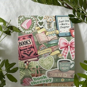 Op de afbeelding: Een decoratief vierkant bedekt met stickers met een boeken thema. Stickers zijn onder meer boeken, strikken, harten en de zinnen "My Happy Place", "Just One - More - Chapter" en "Cup of Coffee". Groen omringt het vierkant.