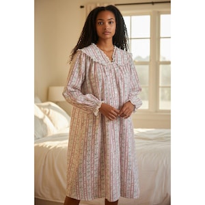 May include: A long-sleeved nightgown featuring a vertical striped pattern in shades of pink and green on a white background. The garment includes a wide, ruffled collar, a button-down front closure, and gathered cuffs at the end of each sleeve.