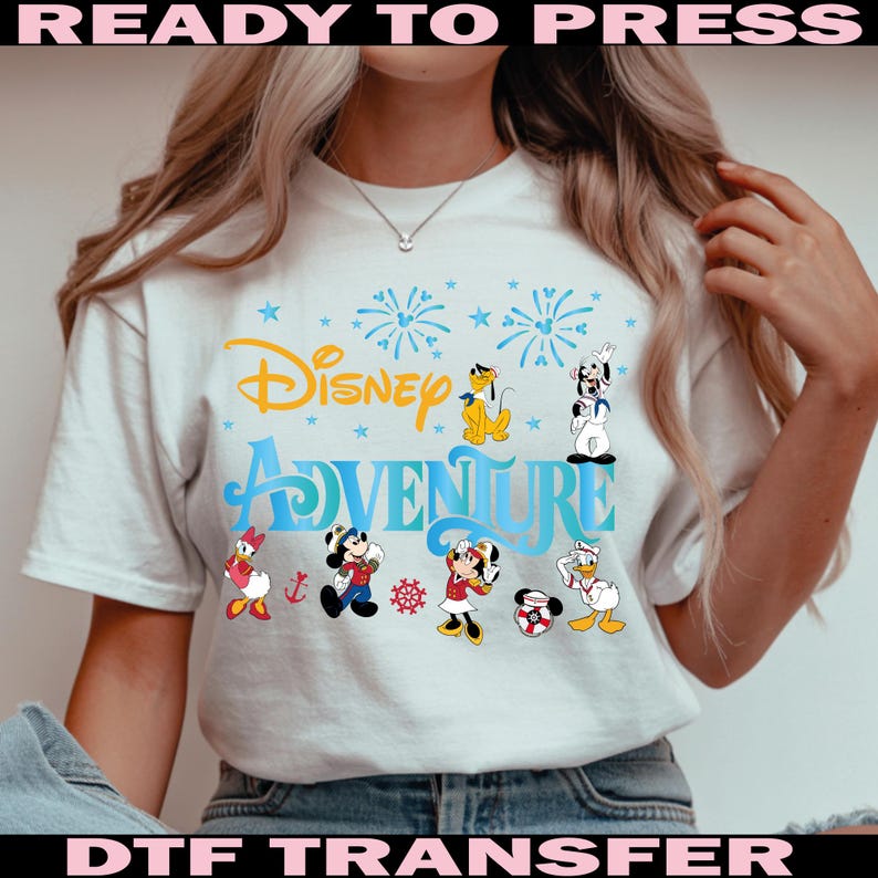 K&ouml;nnte beinhalten: Wei&szlig;es T-Shirt mit dem Schriftzug "Disney Adventure" in Blau und Gelb, mit Zeichentrickfiguren wie Mickey Mouse, Minnie Mouse, Donald Duck und Pluto. Das Design beinhaltet Feuerwerk und Sterne.