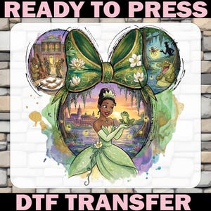 May include: DTF transfer featuring a princess in a green gown holding a frog, set within a Mickey Mouse ear design. The design includes a green bow, a jazz band, and a bayou scene with an alligator. Text reads "READY TO PRESS" and "DTF TRANSFER".