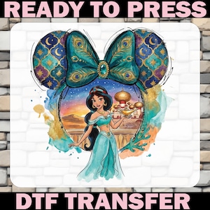 May include: A DTF transfer featuring Princess Jasmine from Aladdin, framed by a teal bow and mouse ears with gold accents. The image includes the text "READY TO PRESS" and "DTF TRANSFER".