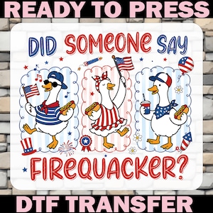 May include: A DTF transfer sheet featuring three cartoon ducks celebrating with hot dogs, American flags, and fireworks. The text reads "DID SOMEONE SAY FIREQUACKER?" in red and blue. The design includes stars, stripes, and patriotic accessories.