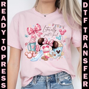 Puede incluir: Camiseta rosa claro con un dise&ntilde;o caprichoso que presenta el texto "Literally just a girl". El gr&aacute;fico incluye un gran lazo rosa, orejas de Minnie Mouse, un zapato de cristal y varios alimentos. Transferencia DTF.