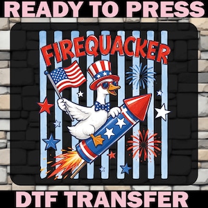 May include: A DTF transfer print featuring a white duck wearing a patriotic top hat, sunglasses, and a bow tie, riding a red, white, and blue firework rocket. The duck holds an American flag. The text reads FIREQUACKER, READY TO PRESS, DTF TRANSFER.