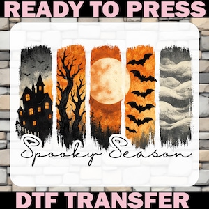 May include: A rectangular DTF transfer sheet featuring five vertical panels with Halloween imagery. The design includes a haunted house, bare trees, a full moon, flying bats, and clouds, with the text "Spooky Season" and "READY TO PRESS".