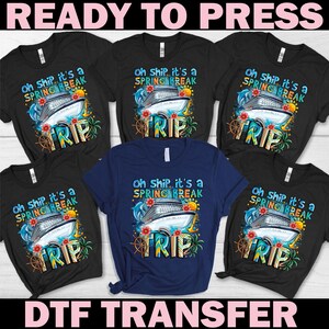 May include: A collection of black and navy blue t-shirts with a colorful graphic design. The design features a cruise ship, dolphins, flowers, and the words "Oh ship, it's a Spring Break TRIP". The words "READY TO PRESS" and "DTF TRANSFER" are also visible.