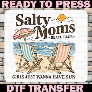 May include: A DTF transfer design featuring a beach scene with two beach chairs, an umbrella, and the text "Salty Moms Beach Club." The design includes the phrase "Girls Just Wanna Have Sun" and is ready to press.