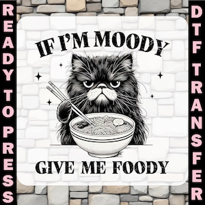 May include: A black and white graphic of a grumpy cat with chopsticks and a bowl of noodles. The text says "IF I'M MOODY GIVE ME FOODY". The image is labelled "READY TO PRESS" and "DTF TRANSFER".