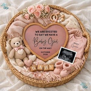 May include: A wicker basket holds a heart-shaped announcement with the text "We are excited to say we have a Baby Girl on the way October 2026." The basket also contains a teddy bear, baby shoes, a onesie, ultrasound image, and wooden blocks spelling "BABY."