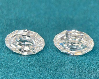 May include: Two oval-cut, clear gemstones with multiple facets are displayed on a teal surface. The gemstones are positioned side by side, reflecting light and appearing brilliant. The overall composition suggests a focus on jewelry or gemstones.