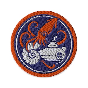 May include: Embroidered patch featuring a stylized orange squid and a submarine design. The patch has a blue background with a white nautilus shell and submarine. The outer border is orange.