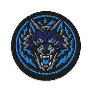 May include: Embroidered patch featuring a snarling wolf's head in shades of blue, gray, and white, set against a black circular background. The wolf's face is detailed with sharp teeth and piercing eyes, surrounded by a blue lightning bolt design.