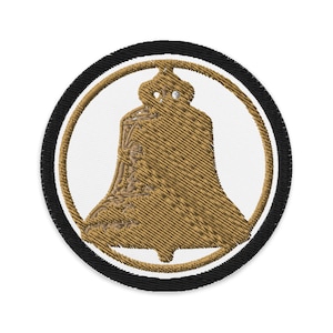 May include: Embroidered patch with a detailed bell design in gold and brown, set against a white backdrop. The bell is within a gold ring, which is then surrounded by a black and white border. Suitable for sewing onto clothing or accessories.
