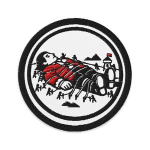 Könnte beinhalten: Gestickter Aufnäher mit kreisförmigem Design. Der Aufnäher zeigt eine Figur in roter Kleidung, die liegt, umgeben von schwarzen Linien und einem schwarz-weißen Rand. Im Hintergrund sind ein kleines Gebäude und Berge zu sehen.