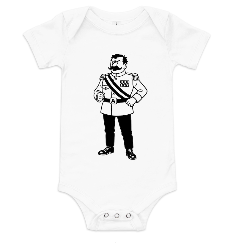 May include: White baby bodysuit featuring a black and white illustration of a cartoon character in a military uniform. The character has a large mustache and is wearing a sash and medals. The bodysuit has short sleeves and a snap closure.