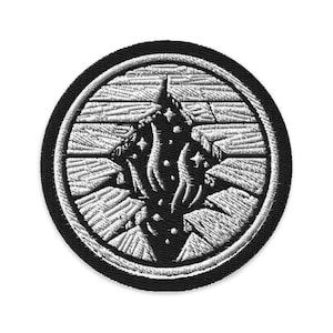 Könnte beinhalten: Runder, gestickter Aufnäher mit einem schwarzen Rand. Das Design zeigt eine weiße, stilisierte Flamme oder Sternenexplosion in der Mitte, vor einem schwarzen Hintergrund. Das Design umfasst einen gerissenen, strukturierten Rand.