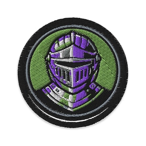 Könnte beinhalten: Gestickter Aufnäher mit einem Ritterhelm in Lila, Grün und Silber. Der Helm befindet sich in einem grünen Kreis, der von einem schwarzen Rand umgeben ist. Das Design ist detailliert und scheint maschinell gestickt zu sein.