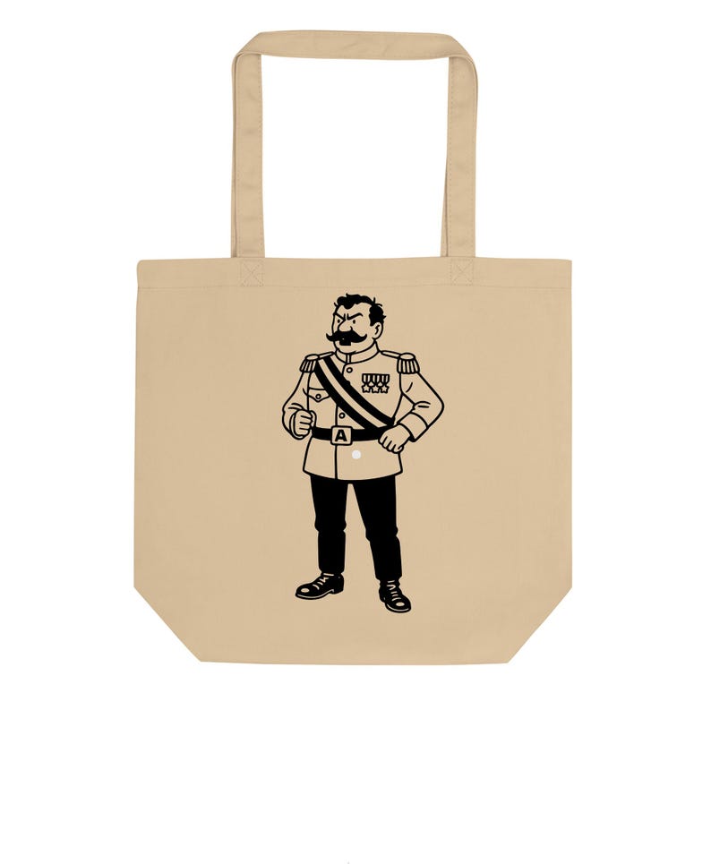 May include: Beige tote bag featuring a black and white illustration of a stern-looking man in a military uniform. The illustration includes a large mustache, medals, and a sash. The bag has two handles.