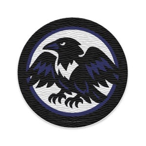 Könnte beinhalten: Ein kreisförmiger Aufnäher mit einem schwarzen Raben mit ausgebreiteten Flügeln, vor einem weißen und blauen Hintergrund. Der Rabe ist mit blauen Akzenten detailliert, und der Rand hat ein strukturiertes, wellenartiges Muster.