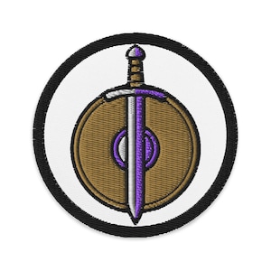 May include: Embroidered patch featuring a shield and sword design. The shield is brown with a purple and white center, and the sword is white and purple. The patch is circular, with a black border and a white background.