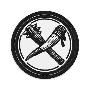 May include: Embroidered patch featuring a crossed club and mace design in black on a white background, encircled by a black border. The patch has a circular shape and is suitable for apparel or accessories.