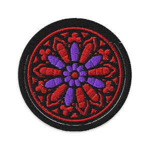 Peut inclure: Écusson brodé rond noir avec un motif de vitrail. Le motif comprend des motifs floraux rouges et violets. L'écusson est circulaire et possède une bordure cousue.