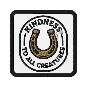 May include: Embroidered patch with a black border and a white background. The patch features a horseshoe in the center, surrounded by the words "KINDNESS TO ALL CREATURES" in a circular design. The horseshoe is brown and gold.