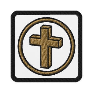 May include: Embroidered patch featuring a gold cross within a gold circle, set against a white background. The design is framed by a black border. The cross has a three-dimensional appearance, adding depth to the religious symbol.