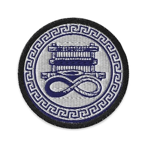 Puede incluir: Parche bordado con un diseño circular. El parche presenta un emblema azul y blanco con un símbolo de infinito y una forma rectangular apilada, rodeado por un borde de clave griega. El parche tiene un borde negro.