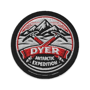 May include: Embroidered patch with a black border featuring a mountain range, crossed ice axes, and the text "DYER ANTARCTIC EXPEDITION" in red and white. The patch is circular.
