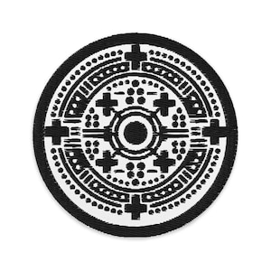Könnte beinhalten: Runder, schwarz-weißer, gestickter Aufnäher mit einem symmetrischen geometrischen Design. Das Design umfasst Kreuze, Kreise und gepunktete Linien, wodurch ein detailliertes Muster entsteht. Der Aufnäher hat einen schwarzen Rand.