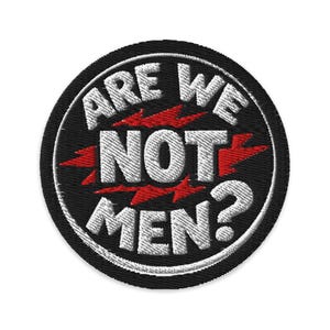 Könnte beinhalten: Runder, gestickter Aufnäher mit dem weißen Schriftzug "ARE WE NOT MEN?" auf schwarzem Grund. Rote Blitz-Grafiken sind zwischen den Wörtern platziert. Der Aufnäher hat einen weißen Rand.