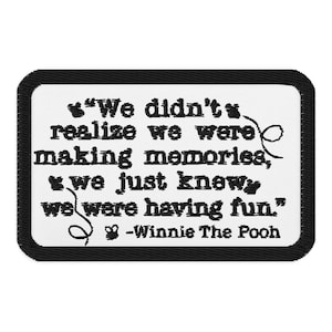 Könnte beinhalten: Ein rechteckiger Aufnäher mit schwarzem Rand und weißer Mitte. Der Aufnäher zeigt das Zitat "Wir haben nicht gemerkt, dass wir Erinnerungen schaffen, wir wussten einfach, dass wir Spaß haben." von Winnie the Pooh, in schwarzem Text.