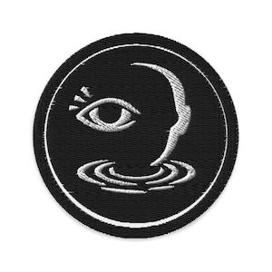 May include: Embroidered black patch with a white border. The design features a stylized eye, a profile, and concentric water ripples. The eye is open with rays emanating from it. The profile appears to be emerging from the water.
