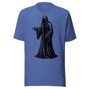 May include: Blue t-shirt featuring a black graphic of a hooded figure pointing. The figure has a long robe and a featureless face. The design is centered on the front of the shirt.