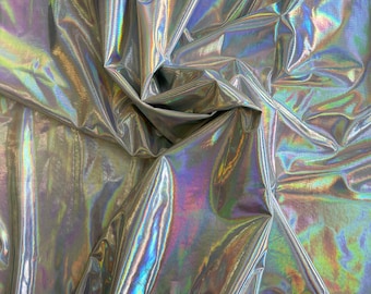 May include: Close-up of iridescent fabric with a silver base and a rainbow sheen. The fabric is wrinkled and folded, creating a textured surface.