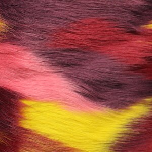 May include: Close-up of a colorful faux fur fabric with shades of pink, red, yellow, and purple. The fabric has a soft, fluffy texture.