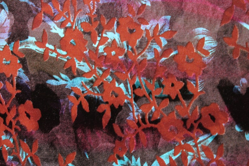 May include: Red floral pattern on a dark brown fabric background. The floral pattern is a silhouette of leaves and flowers.